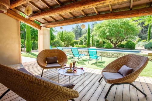 a patio with chairs and a table and a pool at Villa Les Alpilles by Villa Plus in Mouriès