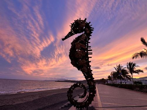a statue of a seahorse on the beach at sunset at Casa Alejandro II in Tarajalejo