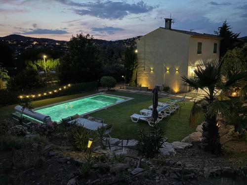une cour arrière avec une piscine et une maison dans l'établissement Belle maison avec piscine privative dans une résidence calme et securisee, à Sainte-Maxime