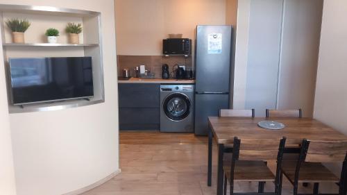 La cuisine est équipée d'une table à manger et d'un réfrigérateur. dans l'établissement Charmant T3 jacuzzi, à Clairvaux-les-Lacs