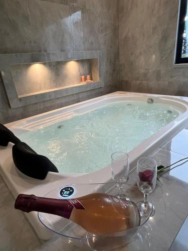 a bath tub with two wine glasses and a bottle of wine at Grand Hill Hotel in Piraí do Sul