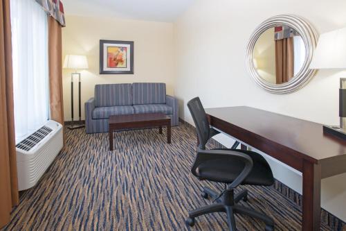 a hotel room with a desk and a chair at Holiday Inn Express & Suites Denver North - Thornton by IHG in Thornton