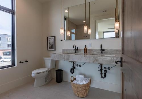 a bathroom with a sink and a toilet and a mirror at Newly Built - South Teton at The Basin Luxury Suit in Driggs
