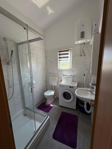 a bathroom with a shower and a toilet and a sink at Apartmani Versizo Rogoznica in Sevid