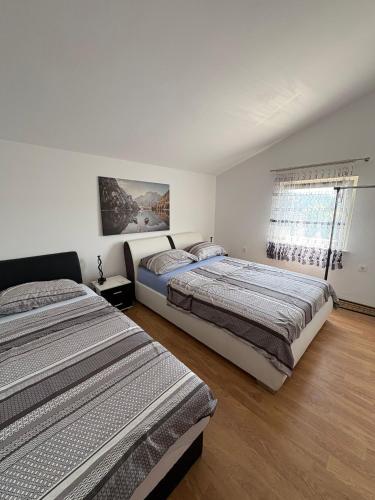 a bedroom with two beds and a window at Apartmani Versizo Rogoznica in Sevid