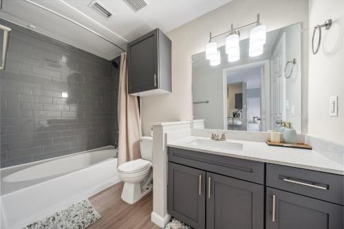 a bathroom with a sink and a toilet and a tub at Houston Lakeside Living in Houston