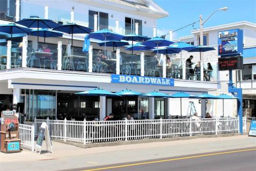a restaurant with blue umbrellas in front of a building at Hampton Tides-Ocean View-Top Floor With Balcony in Hampton