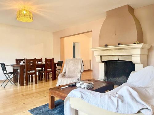 un salon avec une cheminée et une table dans l'établissement Casa Corniou - Calme, Village Provençal, 3 chambres, 2 SDB, 6 personnes, à Cornillon-Confoux