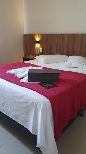a hotel room with two beds with a red blanket at Brisa Parque Hotel in Erechim