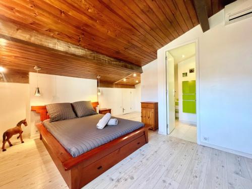 une chambre avec un lit avec un plafond en bois dans l'établissement Casa Corniou - Calme, Village Provençal, 3 chambres, 2 SDB, 6 personnes, à Cornillon-Confoux