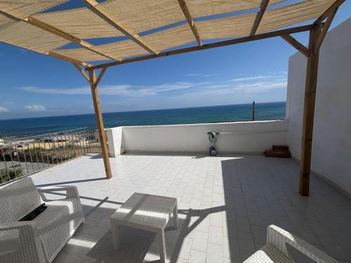 a patio with chairs and a view of the ocean at Casa Lido in Sciacca