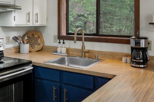 a kitchen counter with a sink and a coffee maker at Chalet Malm - Treetop Mountain Cabin in Basye
