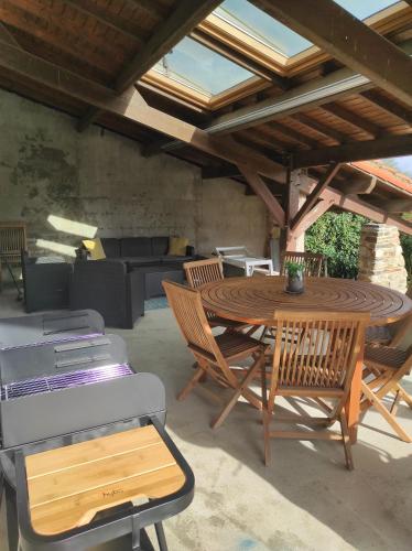 un patio avec une table et des chaises en bois dans l'établissement Calme et reposant, à Joué-Étiau