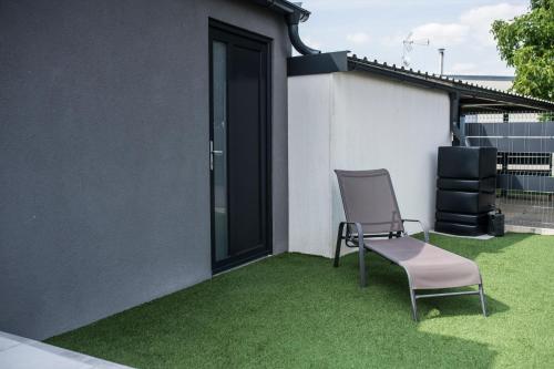 a chair sitting on a patio with green grass at M.F. in Znojmo