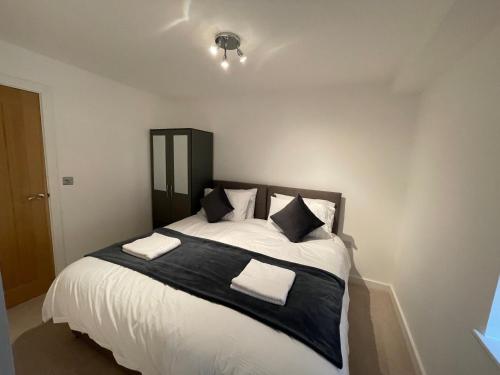a bedroom with a large bed with white sheets and pillows at Lovely 1 bed apartment in the heart of High Wycombe town centre in High Wycombe