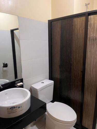 a bathroom with a white toilet and a sink at The Rochester Parklane Condominium in Manila