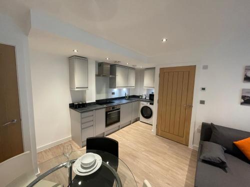 a kitchen and living room with a glass table at Lovely 1 bed apartment in the heart of High Wycombe town centre in High Wycombe