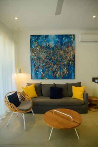 a living room with a couch and a painting on the wall at O'Biches Beachfront Homes - Trou aux Biches in Trou aux Biches