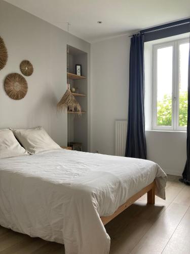 une chambre avec un lit blanc et une fenêtre dans l'établissement Domaine de La Beurrerie, Piscine Naturelle Privée, 5 chambres, Calme absolu, 25mn du PUY DuFou, 2 Logements attenants pour votre Confort, à Saint-Mesmin