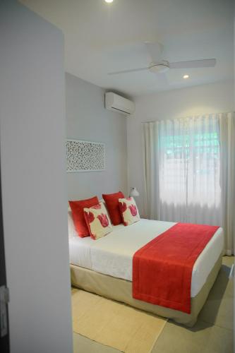 a bedroom with a large bed with red pillows at O'Biches Beachfront Homes - Trou aux Biches in Trou aux Biches