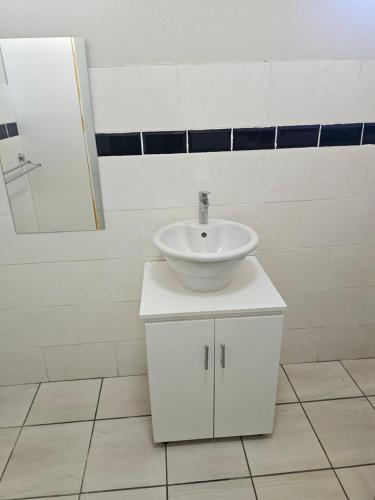 a bathroom with a white sink and a mirror at MP Stop Guest House in Rustenburg