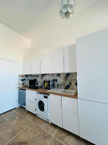 une cuisine blanche avec un évier et une machine à laver dans l'établissement Duplex Premium Cozy - Vue Panoramique - 10 Couchages, à Marseille