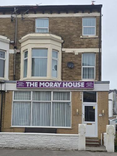 a brown brick building with a purple sign on it at The Moray House in Blackpool