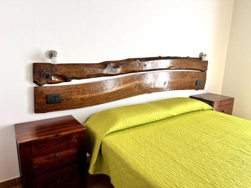 a bedroom with a bed with a wooden headboard at Malochè in Girasole