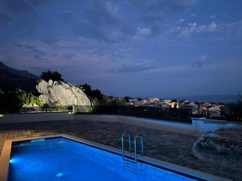 a swimming pool at night with a view at Apartman Magic View in Baška Voda