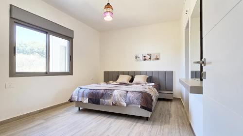 a bedroom with a bed and a window at Tabarja Hills apartment in ‘Ayn aş Şughayrah