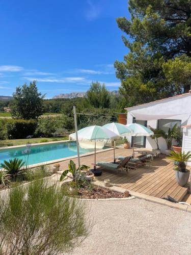 un patio avec des parasols et une piscine dans l'établissement Magnifique villa proche d Aix en Provence, à Rousset