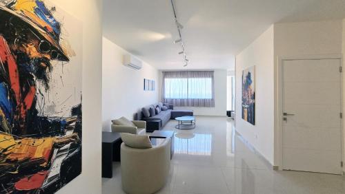 a living room with a couch and a painting on the wall at Tabarja Hills apartment in ‘Ayn aş Şughayrah