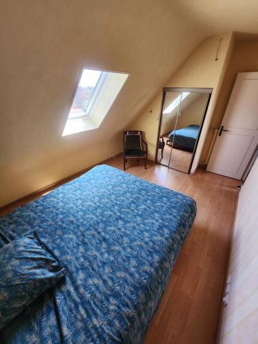 une chambre avec un lit bleu et un miroir dans l'établissement Maison avec Jardin et Jacuzzi, à Lesneven
