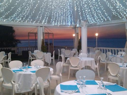 a marquee with white tables and chairs and lights at Hotel Ariana in Marine du Miomo