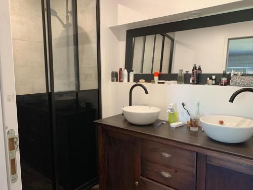 La salle de bains est pourvue de 2 lavabos blancs sur un comptoir en bois. dans l'établissement Maison proche mer, à Lamballe Armor