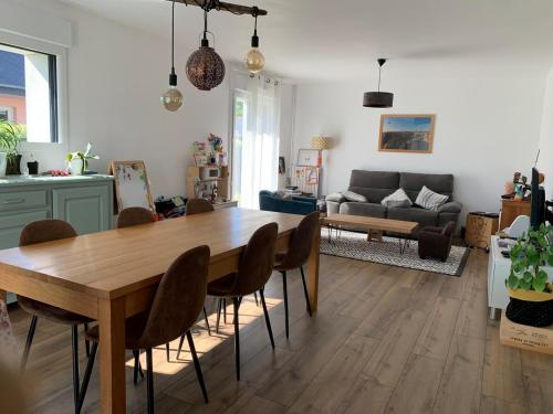 un salon avec une table et des chaises en bois dans l'établissement Maison proche mer, à Lamballe Armor