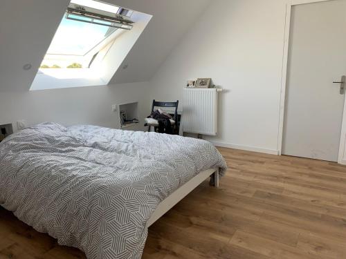- une chambre blanche avec un lit et une lucarne dans l'établissement Maison proche mer, à Lamballe Armor