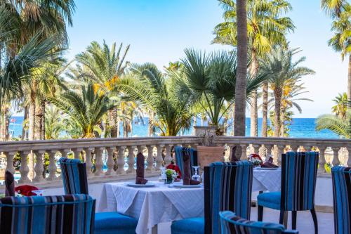 a restaurant on the beach with palm trees and the ocean at Riadh Palms- Resort & Spa in Sousse