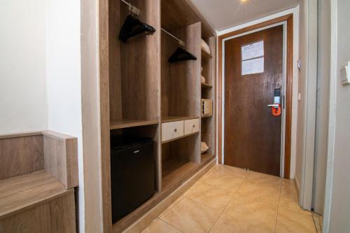 a walk in pantry with wooden cabinets and a door at Riadh Palms- Resort & Spa in Sousse
