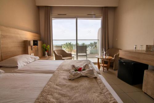 a hotel room with a bed with a towel on it at Riadh Palms- Resort & Spa in Sousse