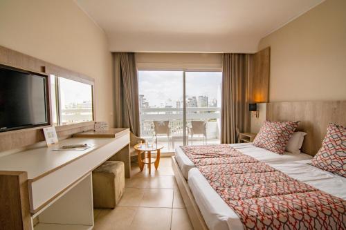 a hotel room with two beds and a television at Riadh Palms- Resort & Spa in Sousse