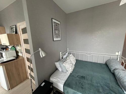 a small bedroom with a bed and a lamp at Апартаменти Світлий Ранок та Затишний Вечір in Rivne