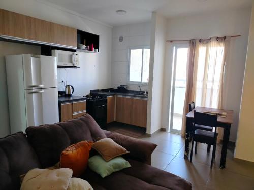 a living room with a couch and a kitchen at Apartamento campolim 2 quartos in Sorocaba