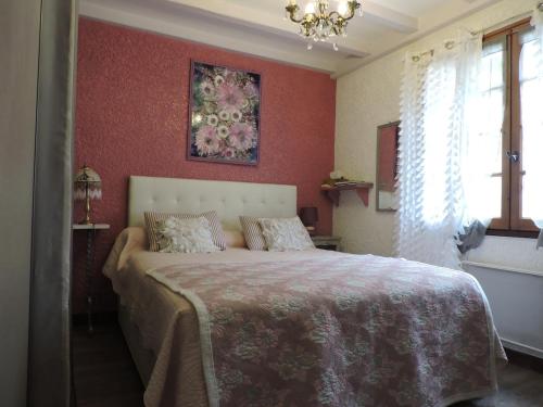 une chambre avec un grand lit aux murs rouges dans l'établissement Villa Zaphira, à Gujan-Mestras