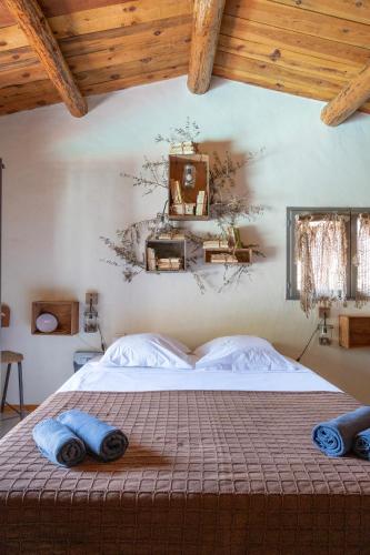 une chambre avec un lit avec des serviettes bleues dessus dans l'établissement Bergerie avec piscine à 5m de Palombaggia - 6 couchages, à Porto-Vecchio