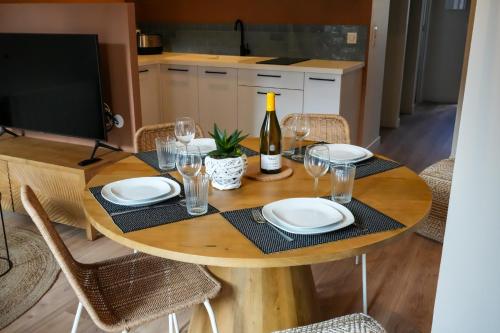 - une table avec des assiettes, des verres et une bouteille de vin dans l'établissement Le Clos de St Val 1, à Saint-Valery-sur-Somme