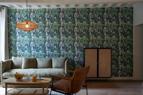 - un salon avec un canapé et du papier peint dans l'établissement Le Clos de St Val 2, à Saint-Valery-sur-Somme