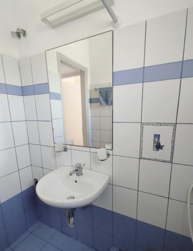 ein weißes Badezimmer mit Waschbecken und Spiegel in der Unterkunft Fos residence in Nea Cryssi Akti