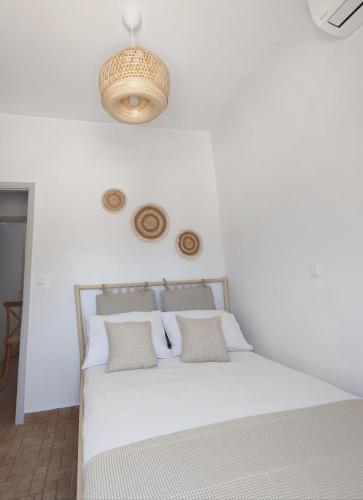 ein weißes Schlafzimmer mit einem Bett mit weißen Wänden in der Unterkunft Fos residence in Nea Cryssi Akti