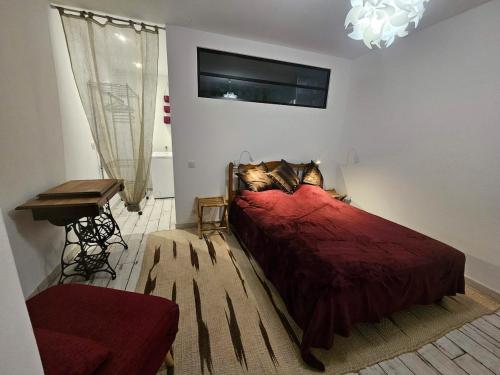 - une chambre avec un lit rouge, une table et un bureau dans l'établissement Beautiful apartment with private garden, à Buros